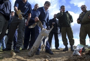 Izraelská policie prohlíží zbytky rakety, která dopadla na vesnici.